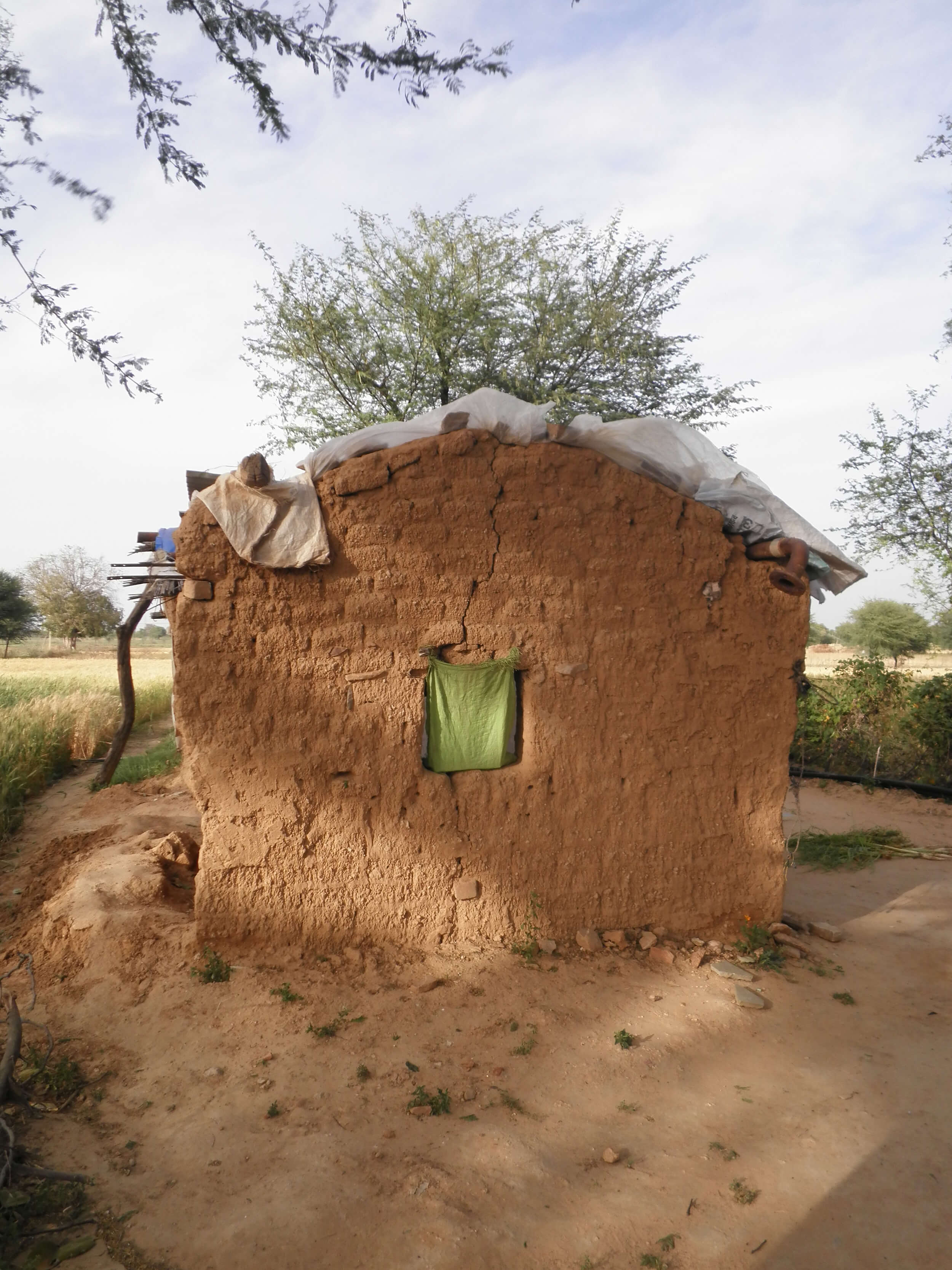 A hut made of dirt on the outskirts of India